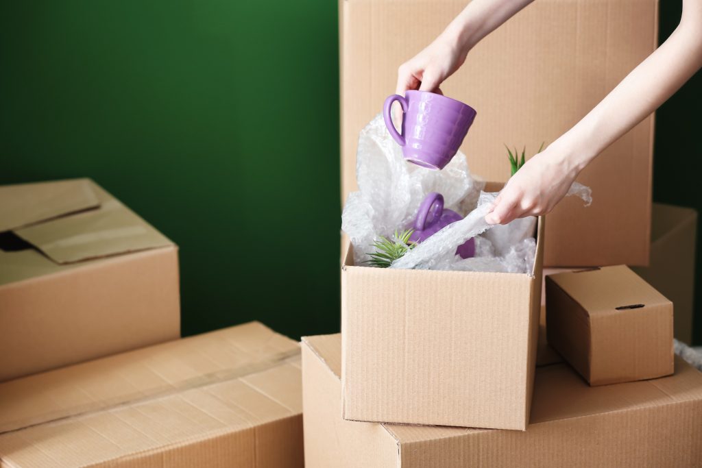 hands packing cup in a moving box