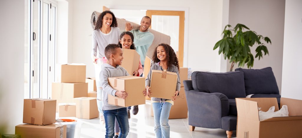 family of five carrying moving boxes