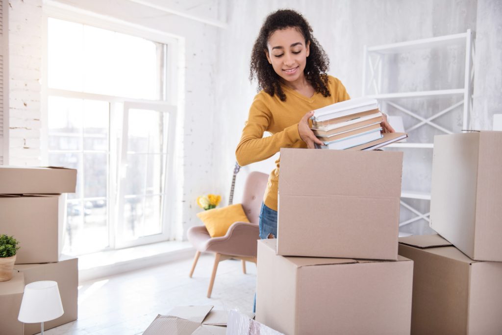 woman packing books in moving boxes