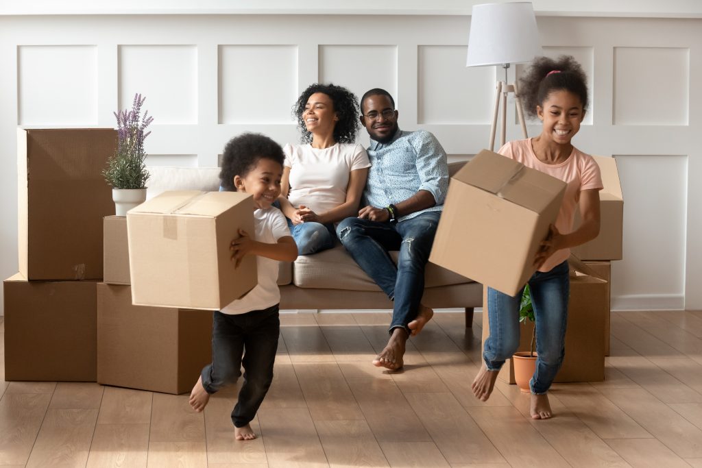 family, kids carrying moving boxes