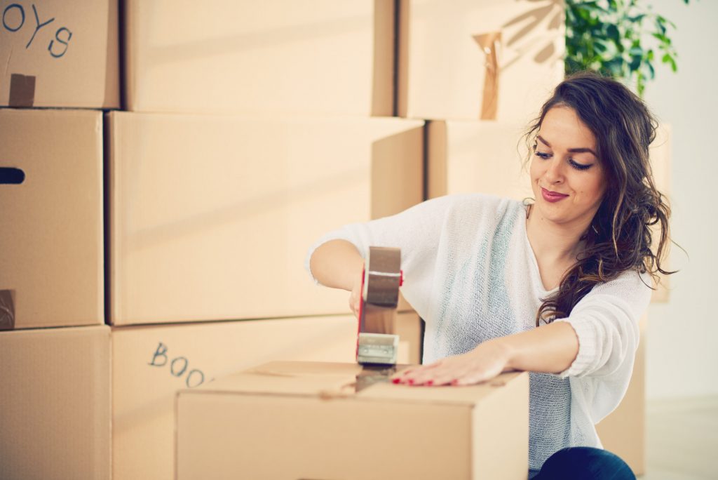 woman taping moving boxes
