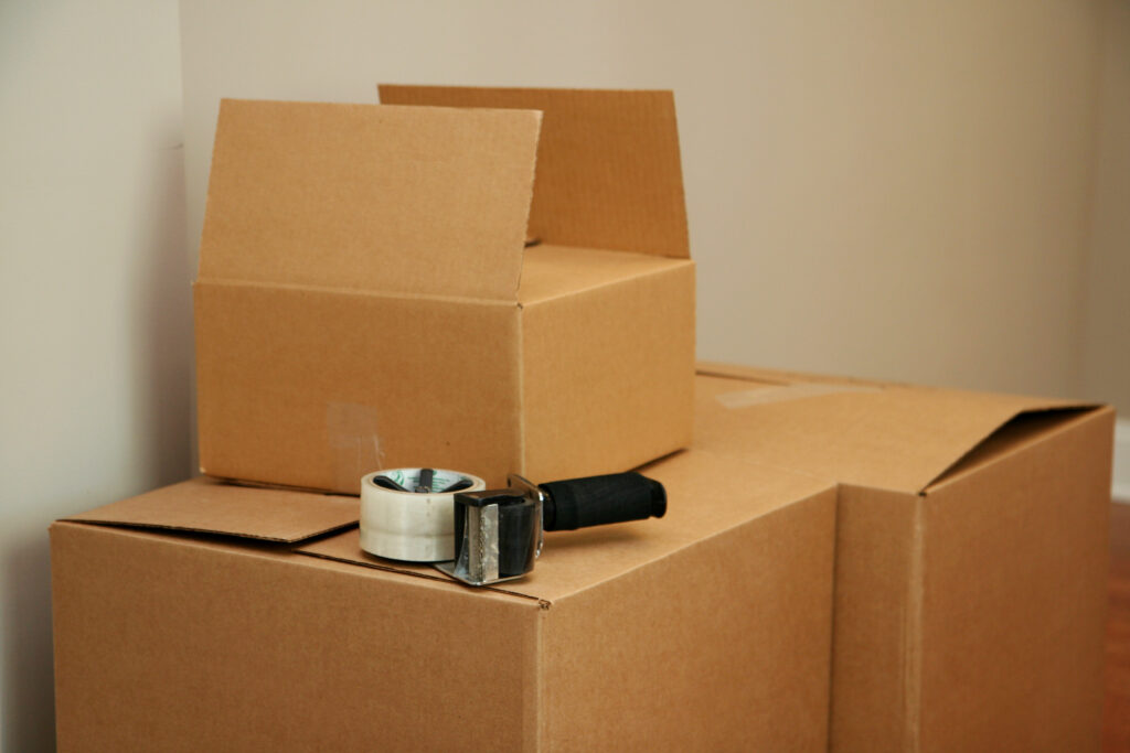 Moving boxes stacked with tape gun sitting on top.